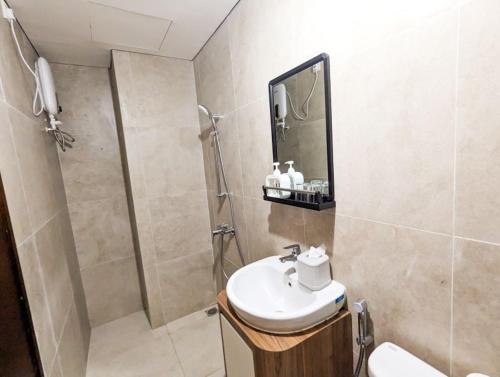La salle de bains est pourvue d'un lavabo et d'une douche. dans l'établissement Lovina 5510 at Pollux Meisterstadt, à Batam Center