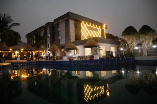 un edificio con una piscina delante de él por la noche en Lamonde Bysomwhere, en Jos