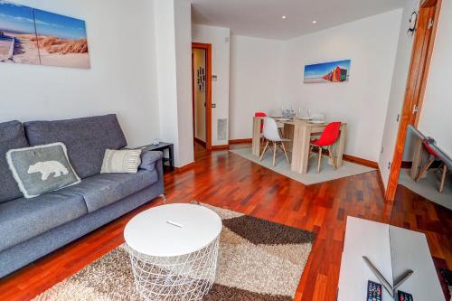 ein Wohnzimmer mit einem Sofa und einem Tisch in der Unterkunft Seaside April Apartment by Hello Homes Sitges in Sitges