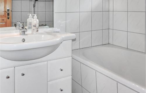 a white bathroom with a sink and a bath tub at Stunning Home In Reisseck-kolbnitz With Kitchen in Zandlach