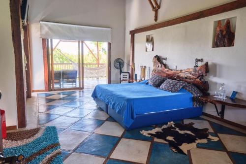 Schlafzimmer mit einem blauen Bett und Fliesenboden in der Unterkunft Finca Turística La Casa que Canta in Quimbaya