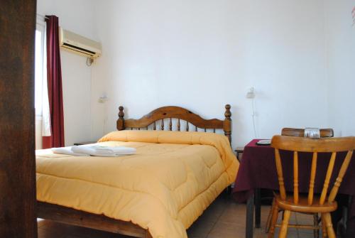 a bedroom with a bed and a table and chairs at Hotel Romi in Colonia del Sacramento
