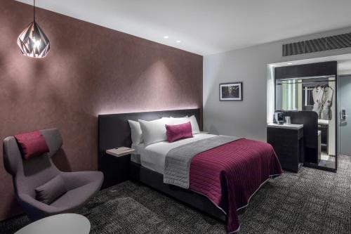 a hotel room with a bed and a chair at Sage Melbourne Ringwood in Ringwood