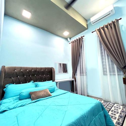 um quarto com uma cama azul e uma almofada castanha em Homestay 2 Story Wakaf Che Yeh em Kota Bharu