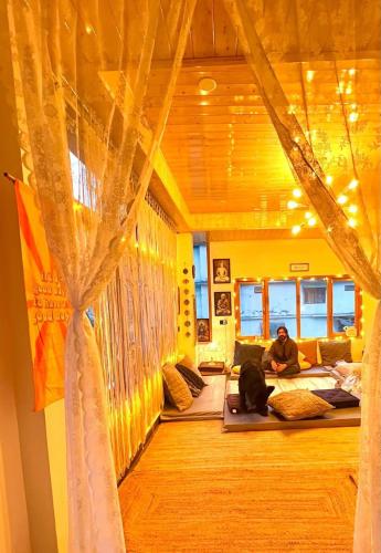 a man sitting on a bed in a room at Buddha house 2 in Kasol