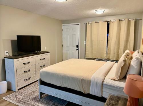 a bedroom with a bed and a flat screen tv at Wildflower Room 15 in Townsend