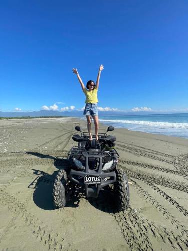 a woman standing on a wheeler on the beach at Lotus Sun & Waves Beach Resort in Baler
