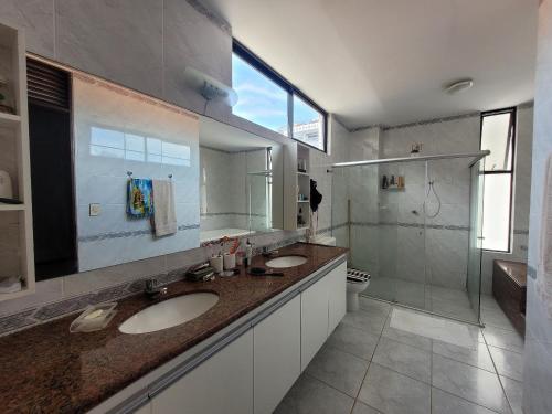 a bathroom with two sinks and a shower at Edifício Monte Sinai in Cabedelo