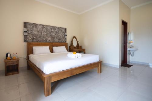 a bedroom with a large bed with white sheets at Alam Canggu Kuta by ABM in Canggu