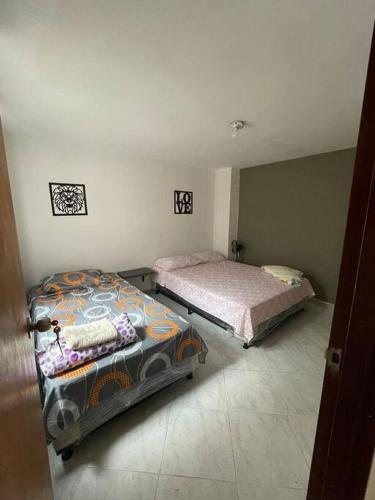 um quarto com duas camas e uma mesa em Casa cómoda y amplia en laureles em Medellín