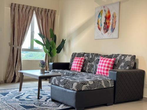 ein Wohnzimmer mit einem Sofa und einem Tisch in der Unterkunft Tiara Desaru Private Beach 0513 By De Home in Bandar Penawar