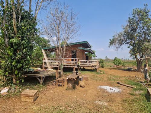 a house with a table and a bench in front of it at Shared Happy Farm in Ban Nongboua
