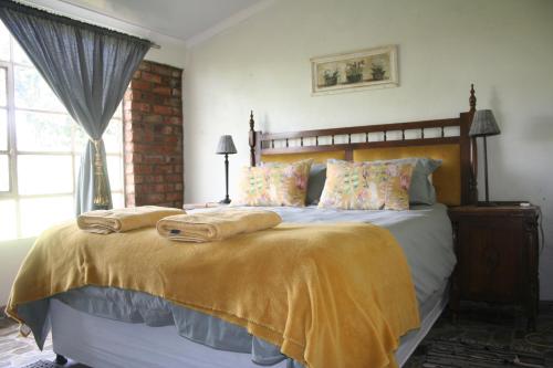 een slaapkamer met een bed met twee handdoeken erop bij Suikerbosskuur Rondavel & Chalet in Amsterdam