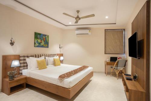 a bedroom with a bed and a flat screen tv at StayVista's Tree House at Sula Wada - Cozy Home with Vintage Charm, Swimming Pool, Indoor Activities in Panchgani