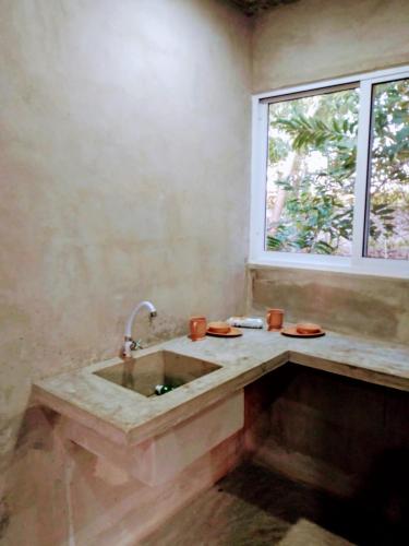 een badkamer met een wastafel en een raam bij Villa maya in Izamal