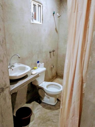 een badkamer met een wit toilet en een wastafel bij Villa maya in Izamal