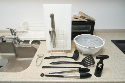 a bunch of kitchen utensils on a counter next to a sink at BETTEI in Oita
