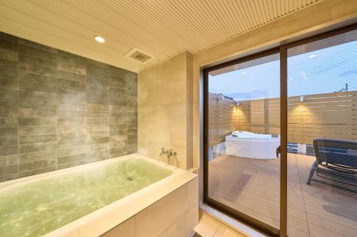 a bath tub in a room with a table at BETTEI in Oita