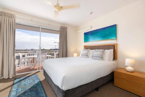ein Schlafzimmer mit einem großen Bett und einem Balkon in der Unterkunft Sunny 'Beachside' Unit Buddina Resort in Buddina