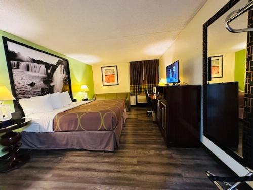 a hotel room with a bed and a flat screen tv at Super 8 by Wyndham Branson/Andy Williams Theatre in Branson