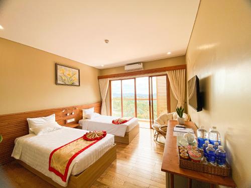 a hotel room with two beds and a television at Memories Hotel in Bảo Lộc