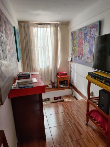 a room with a desk and a table with a keyboard at Departamento privado artístico in La Paz