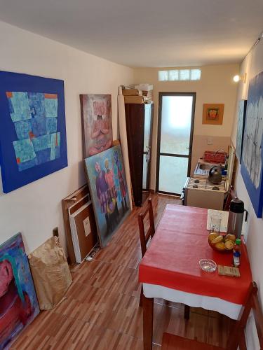a living room with a dining room table and paintings at Departamento privado artístico in La Paz