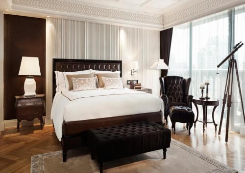 a large bedroom with a large bed and a chair at Hotel Muse Bangkok Langsuan - MGallery in Bangkok