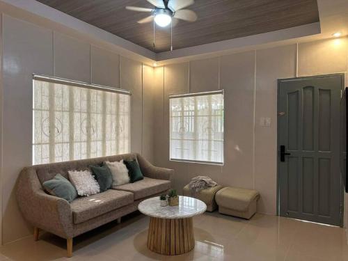 uma sala de estar com um sofá e uma mesa em Japandi Home A - Fully Aircon, WIFI, Hot shower, 24hGuard, Center, near Malls em General Santos