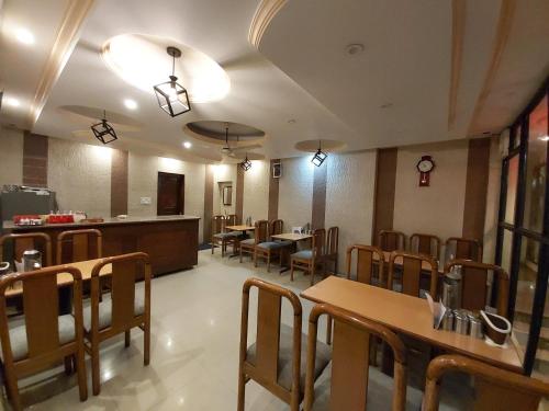 una sala da pranzo con tavoli e sedie in un ristorante di Goroomgo Moon Nainital Near Naini Lake - Parking & Lift Facilities -Hygiene and Spacious Room - Best Seller a Nainital