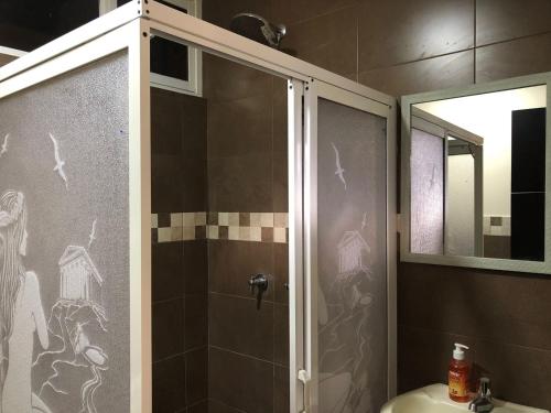 a shower with a glass door in a bathroom at Mini Apartment with terrace in Baños