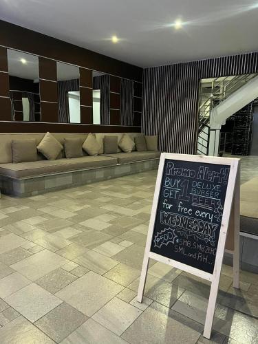 a sign in front of a room with a couch at Chequers Suites Subic Bay in Olongapo