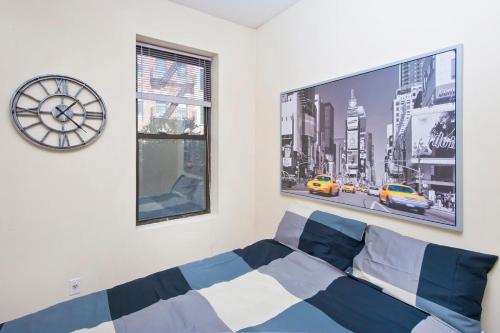 1 dormitorio con reloj grande y sofá en 102-2A Specious 2BR Best Value Near Cntrl Park en Nueva York