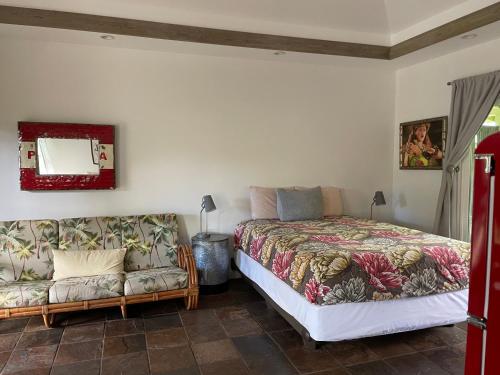 ein Schlafzimmer mit einem Bett und einem Sofa in der Unterkunft Banyan Tree B&B Retreat in Makawao