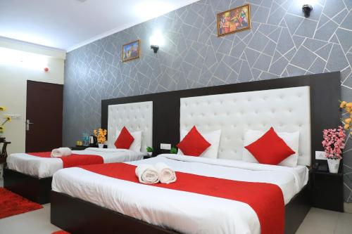 1 dormitorio con 2 camas y almohadas rojas y blancas en Hotel Global Inn By Quality Inn, en Nueva Delhi