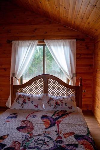 a bed in a room with a window in a cabin at Casa en la Perla del Maule in Constitución