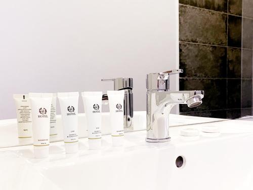 Eine Reihe von Toilettenartikeln steht auf dem Waschtisch im Badezimmer. in der Unterkunft TourAsia Hotel in Bischkek