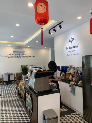 a woman sitting at a counter in a fast food restaurant at Le Palmier Phu Quoc Hotel - Free Shuttle To Grand World in Phu Quoc