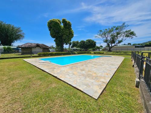 una piscina en un patio con una valla en House in a private residential area en Paea