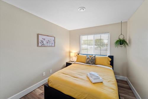1 dormitorio con 1 cama con sábanas amarillas y ventana en The Central Home: 2BR Hideaway, en Kennewick