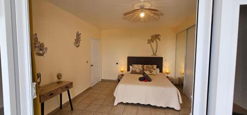 a bedroom with a bed and a chandelier at Cozy House in a private complex in Paea