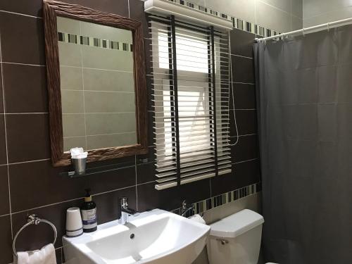 uma casa de banho com um lavatório, um WC e um espelho. em Rimklong boutique hotel trad em Trat