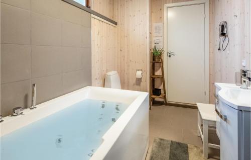 baño con bañera grande y lavamanos en Cozy Home In Brenderup Fyn With Kitchen, en Vedelshave