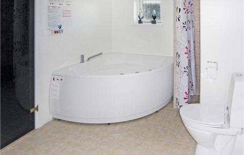 een badkamer met een wit bad en een toilet bij 4 Bedroom Beautiful Home In Rudkbing in Spodsbjerg