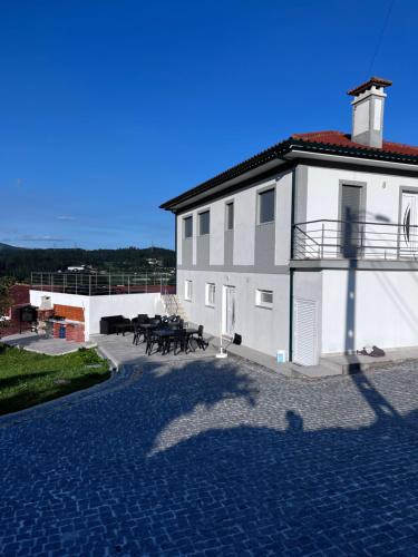 a large white building with tables on the side of it at Casa Alexandre 7 in Monte