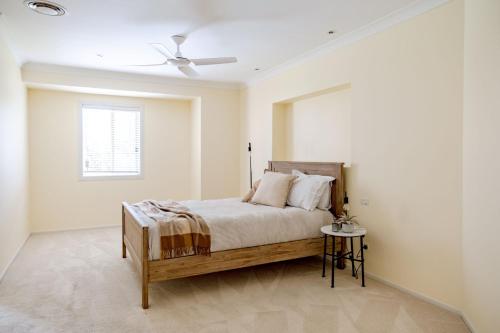 a bedroom with a bed and a ceiling fan at Anchors at Mollymook Beach in Mollymook