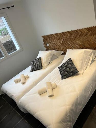 Cette chambre comprend 2 lits avec des draps et des oreillers blancs. dans l'établissement A nepita di porto vecchio***, à Porto-Vecchio