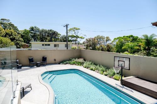 a swimming pool on the side of a house at Anchors at Mollymook Beach in Mollymook