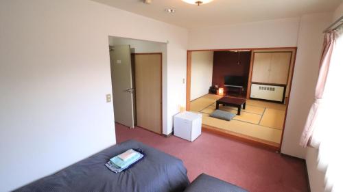 a living room with a couch and a view of a room at Felse Inn Gakusui in Hakuba