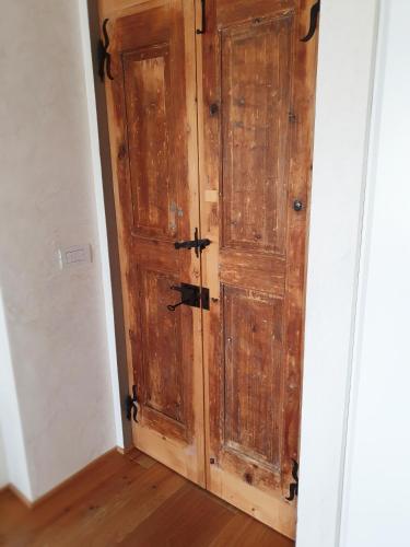 a wooden door in the corner of a room at Relais Poggio Pagnan in Farra
